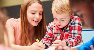 Erzieherin malt mit Kindern