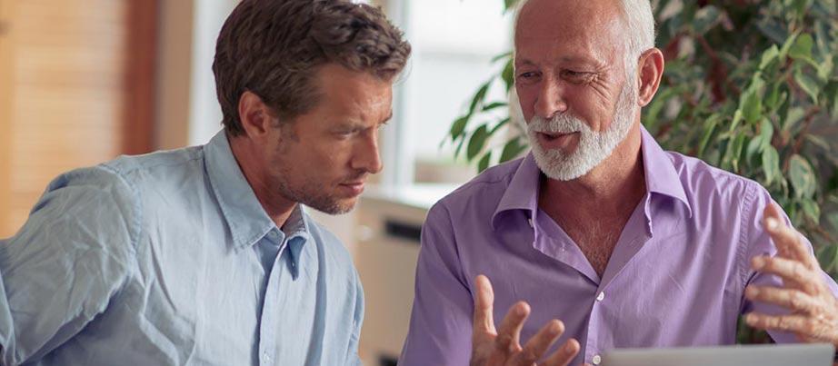 Zwei Männer sind in ein Arbeitsgespräch vertieft.