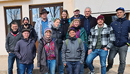 Eine Gruppe von 13 Erwachsenen steht auf einer Treppe.
