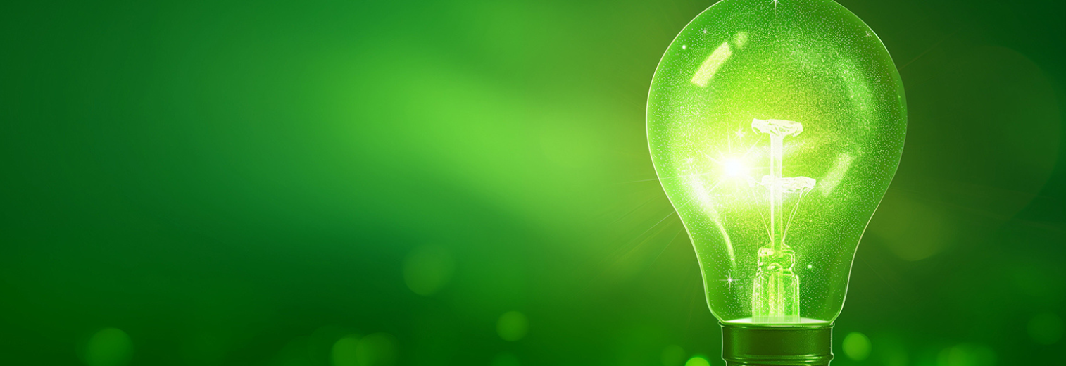 grüne leuchtende Glühbirne vor grünem Grund