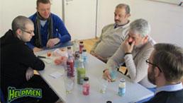 Fünf Männer sitzen an einem Tisch und trinken Smoothies